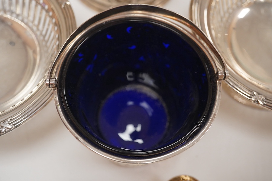 A George III small silver sugar basket, London, 1810, with blue glass liner, 57mm, a George III silver sifter spoon, a pair of silver bonbon dishes and an Edwardian small rose bowl, 16.9oz. Condition - poor to fair to go